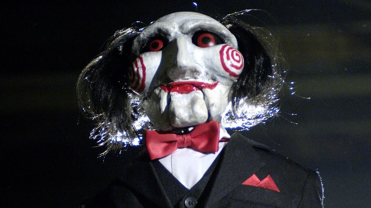 Jogos Mortais - Novo poster do filme mostra o assustador mascote