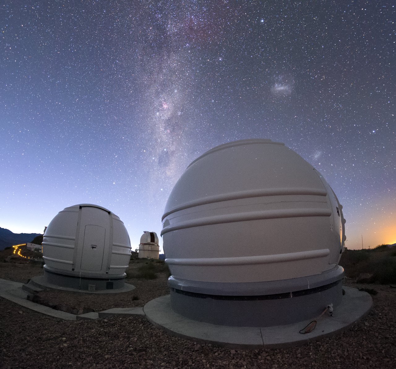 The ExTrA telescopes are sited at ESO’s La Silla Observatory in Chile. They will be used to search for and study Earth-sized planets orbiting nearby red dwarf stars. ExTrA’s novel design allows for much improved sensitivity compared to previous searches. This view shows two of the three ExTrA domes with the Milky Way and Magellanic Clouds visible above.